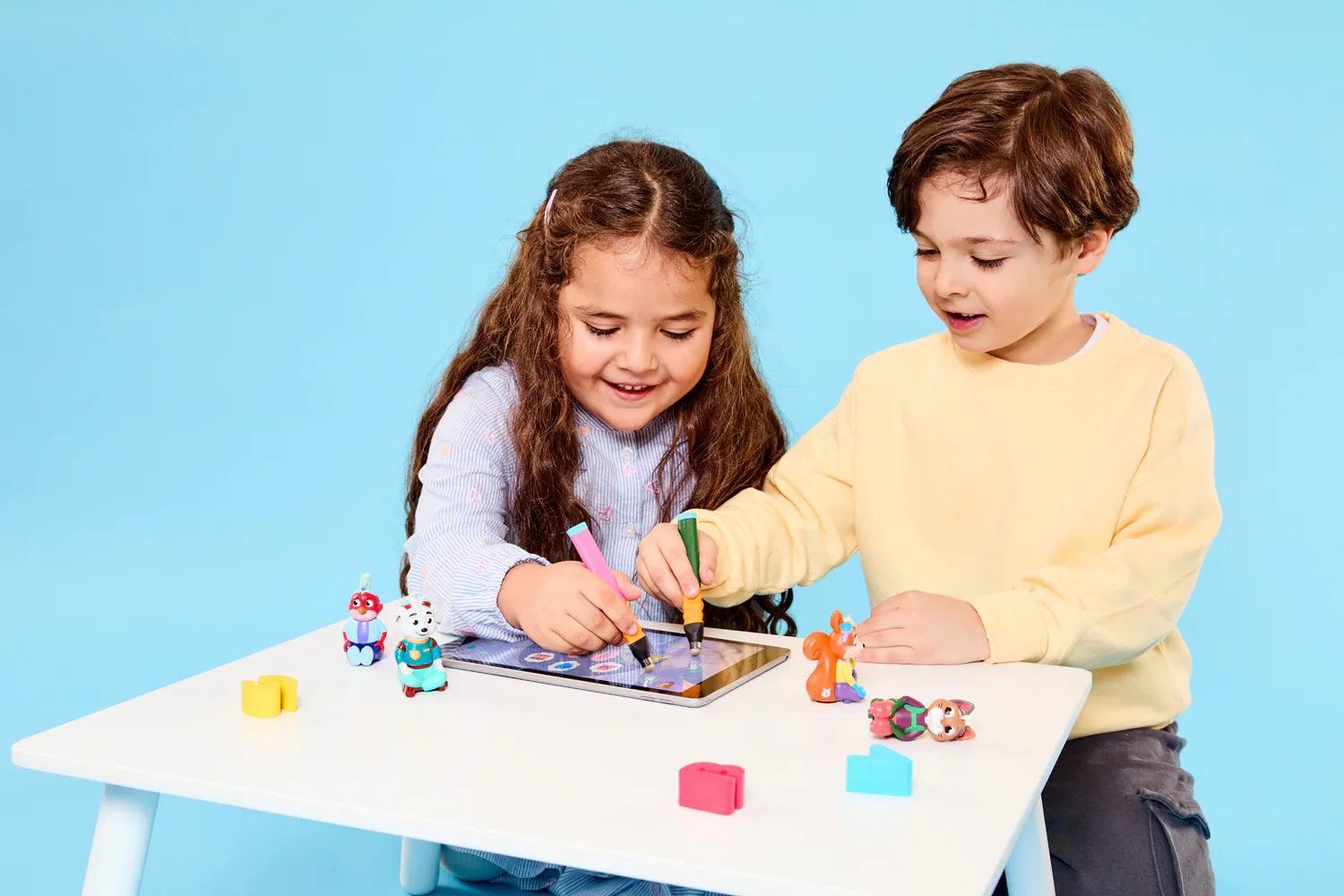 Kinder spielen mit Edurino Figuren und freuen sich