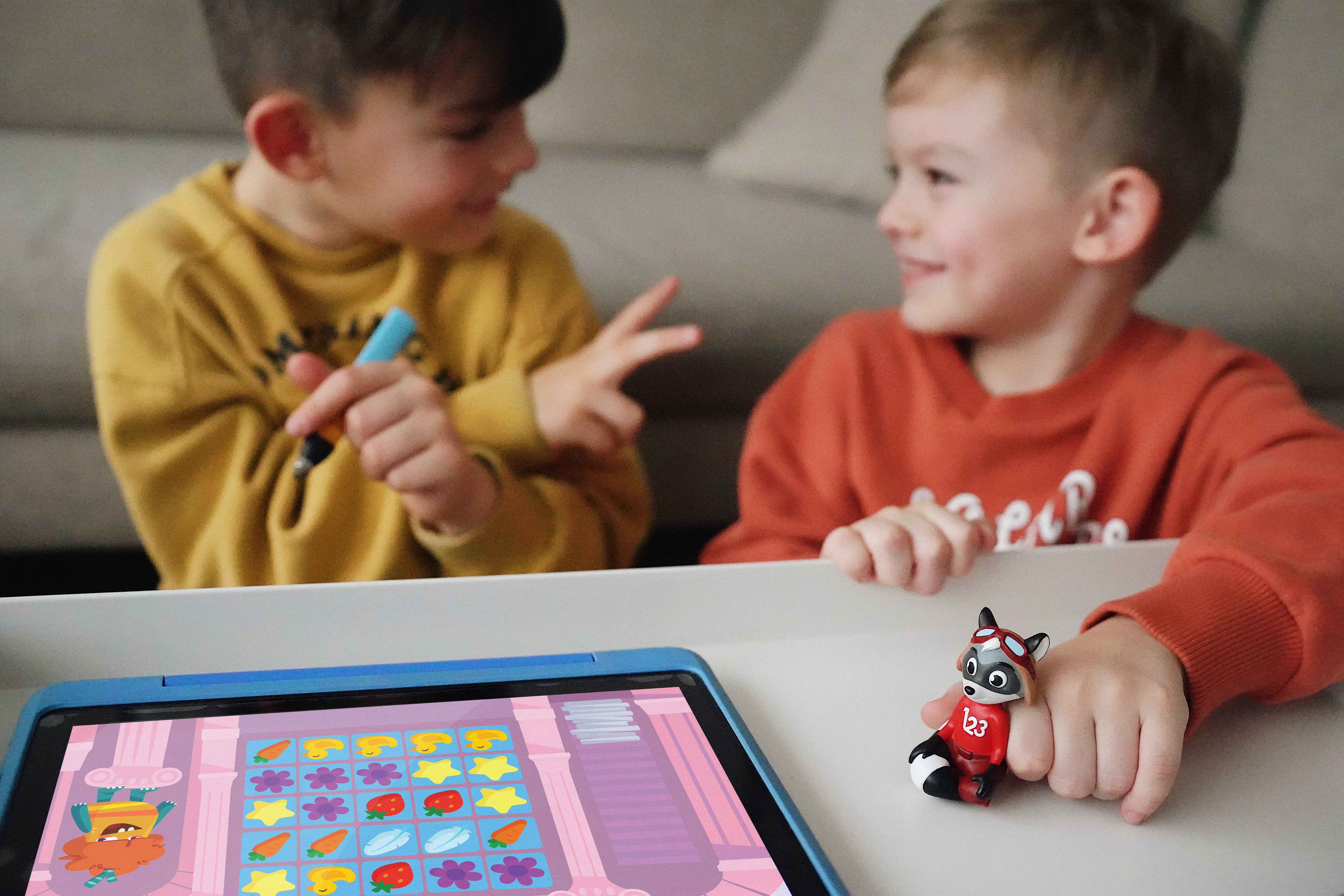 Zwei Kinder am Tablet, ein Junge zeigt die Zahl 2